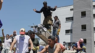 Un soccorritore chiede silenzio durante la ricerca di sopravvissuti dopo il terremoto che ha colpito Cali