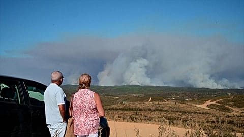 Moradores junto a Valverde del Camino observam colunas de fumo de um incêndio florestal na província de Huelva, no sudoeste de Espanha