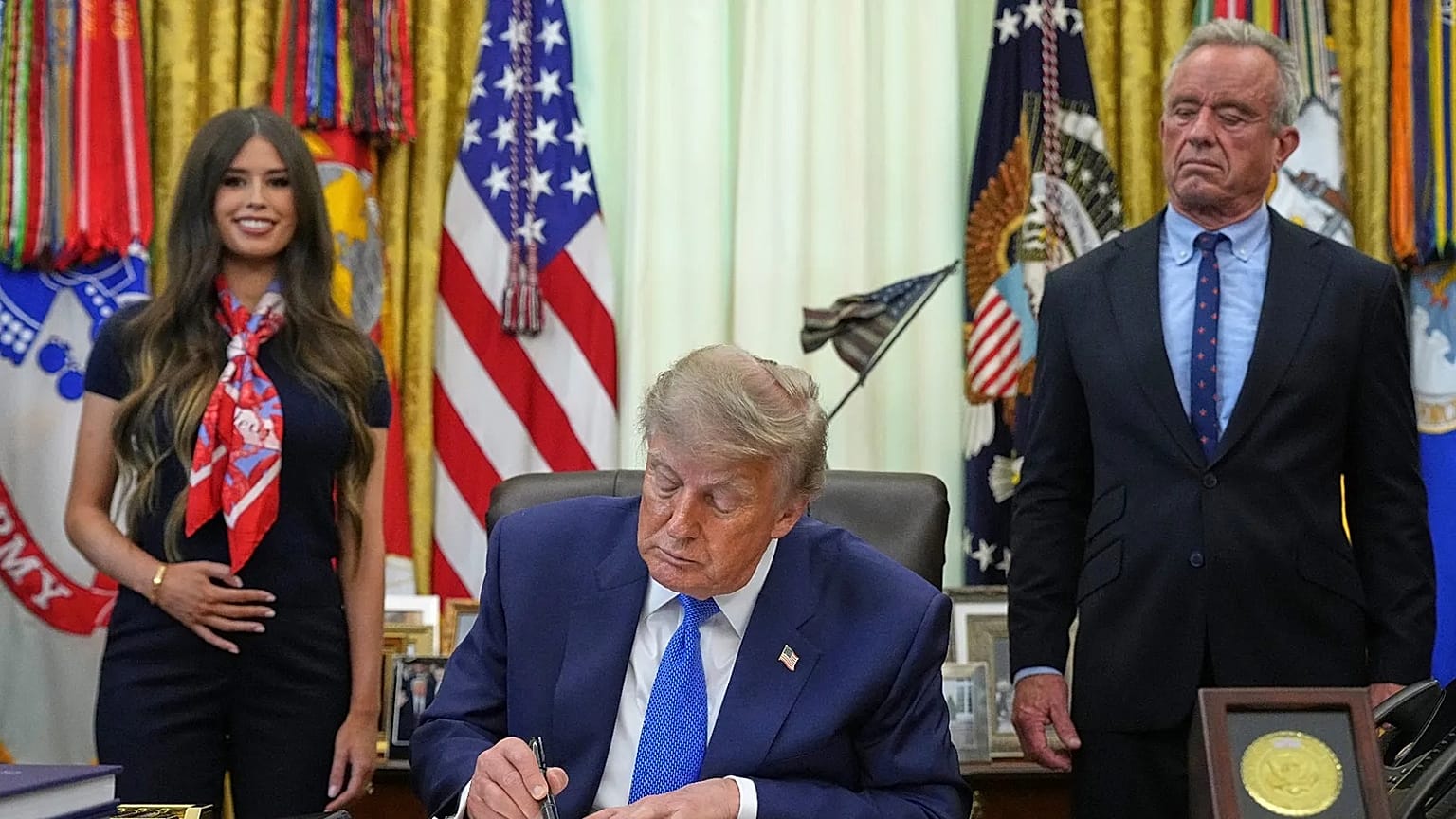 President Donald Trump signs an executive order about vaccines as Jayme Franklin, left, and Health and Human Services Secretary Robert F. Kennedy Jr. watch Monday, Aug. 10, 20