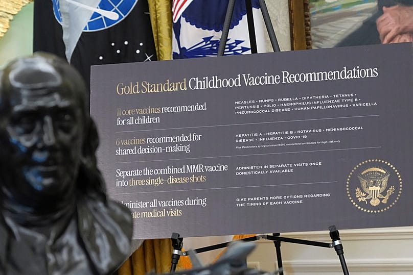 A sign about childhood vaccines is pictured as President Donald Trump speaks during a meeting to sign an executive order, Monday, Aug. 10, 2026, in the Oval Office of the Whit