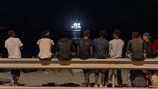 Migrants who crossed into Spain from Morocco gather on a beach in the Spanish enclave of Ceuta, Sunday, Aug. 2, 2026. (AP Photo/Antonio Sempere)