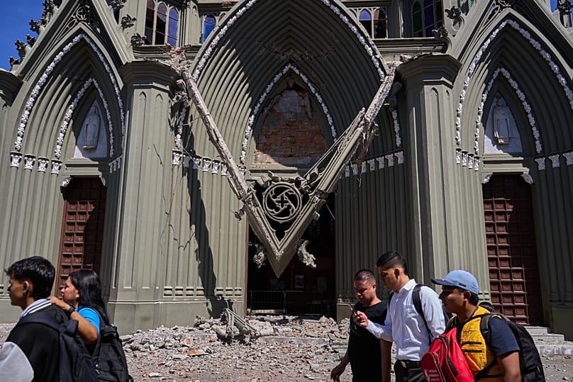 Varias personas caminan junto a una iglesia dañada en Pereira, Colombia, el lunes 10 de agosto de 2026