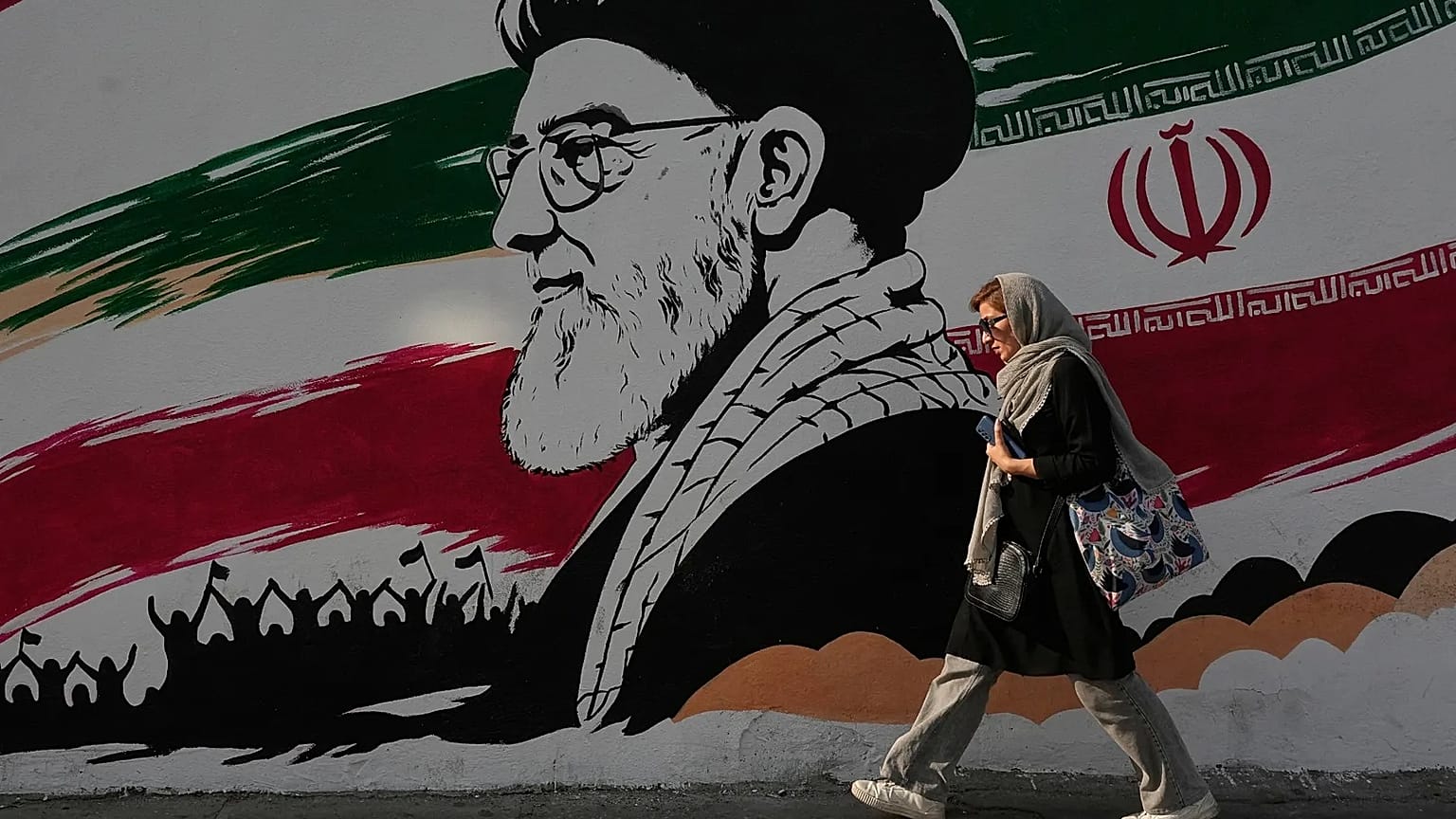 FILE: A woman walks past a mural of the late Iranian Supreme Leader Ayatollah Ali Khamenei on Azadi (Freedom) Street in Tehran, 29 July 2026