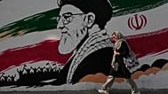 FILE: A woman walks past a mural of the late Iranian Supreme Leader Ayatollah Ali Khamenei on Azadi (Freedom) Street in Tehran, 29 July 2026