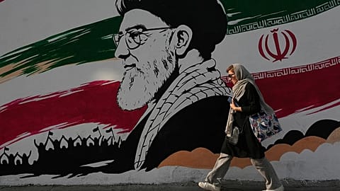 FILE: A woman walks past a mural of the late Iranian Supreme Leader Ayatollah Ali Khamenei on Azadi (Freedom) Street in Tehran, 29 July 2026