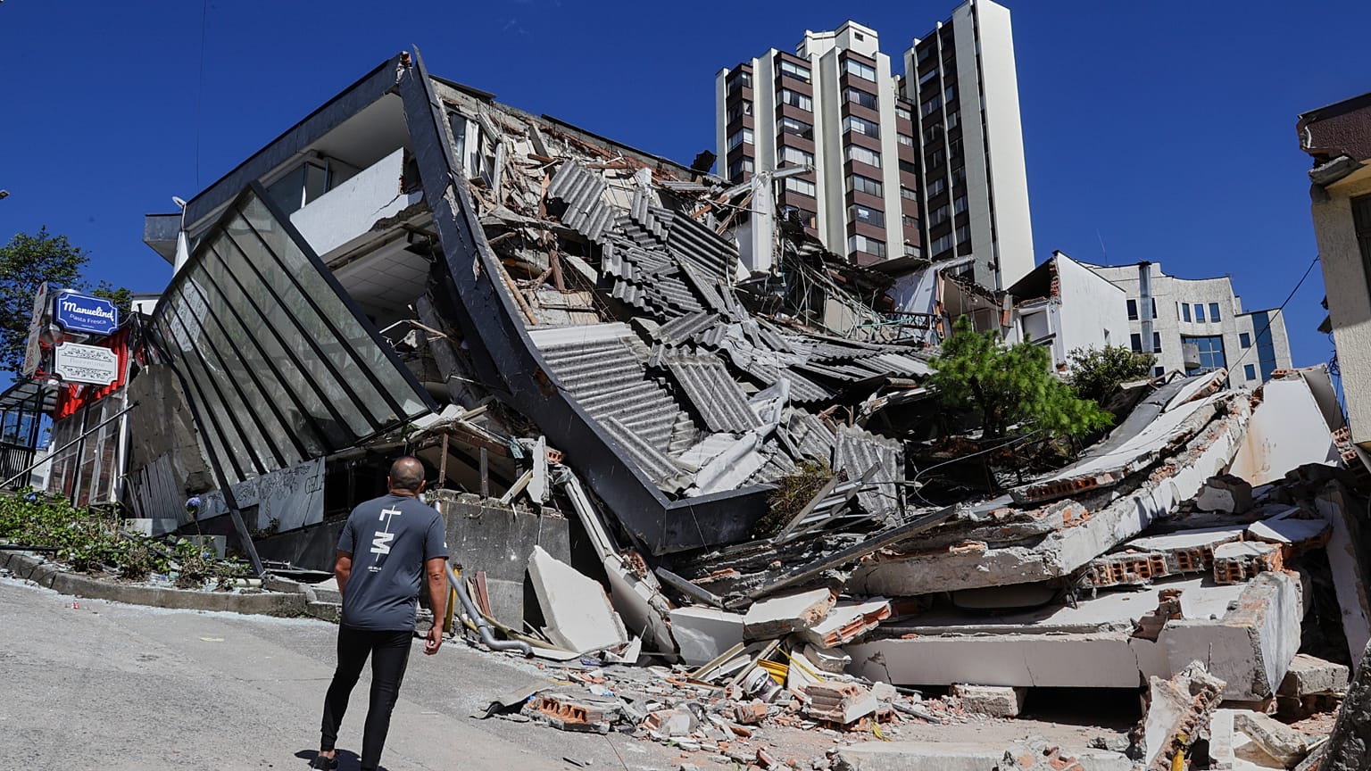 Mężczyzna przygląda się zawalonemu budynkowi po trzęsieniu ziemi, które nawiedziło Manizales.