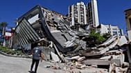 A man looks at a collapsed building after an earthquake struck Manizales