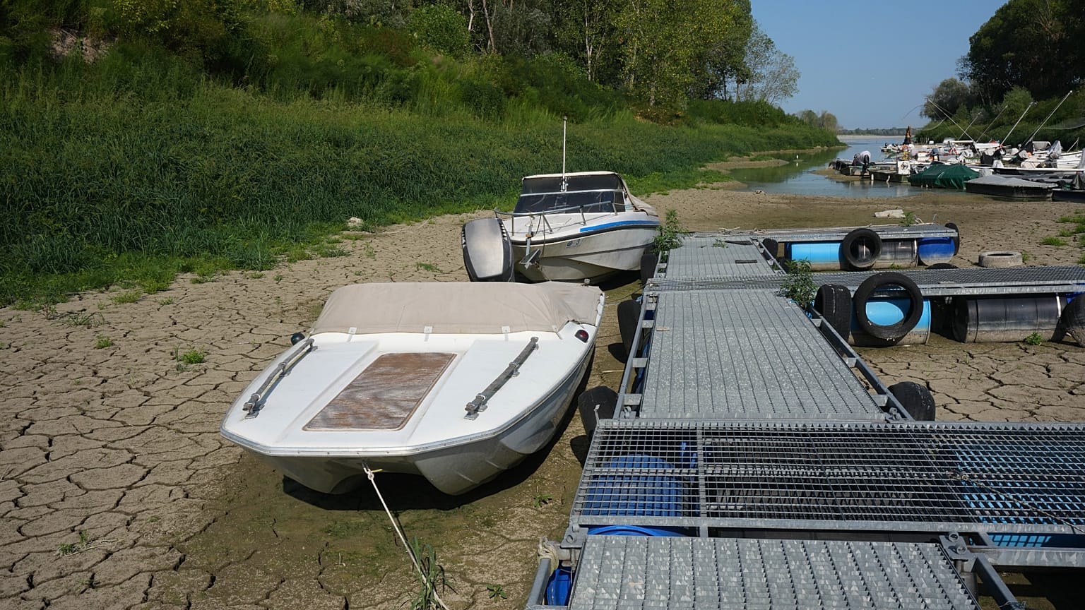 Boats lie on the dry riverbed at a tourist dock along the Po River 