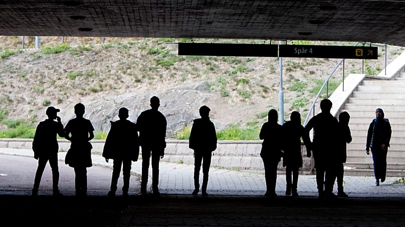 Migrantes caminan bajo un puente ferroviario en la localidad de Flen, a unos 100 kilómetros al oeste de Estocolmo, Suecia, 30 de agosto de 2018.