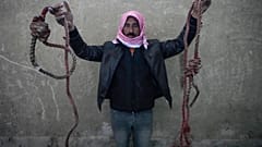 رجل يحمل حبلين مربوطين على شكل حبال مشنقة، تم العثور عليهما في سجن صيدنايا العسكري سيئ السمعة، شمال دمشق، سوريا، الاثنين 9 ديسمبر 2024.