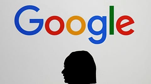 ARCHIVES - A woman walks past a giant screen displaying the Google logo during an event at the Google Lab in Paris, on the sidelines of the 'AI Action' summit.