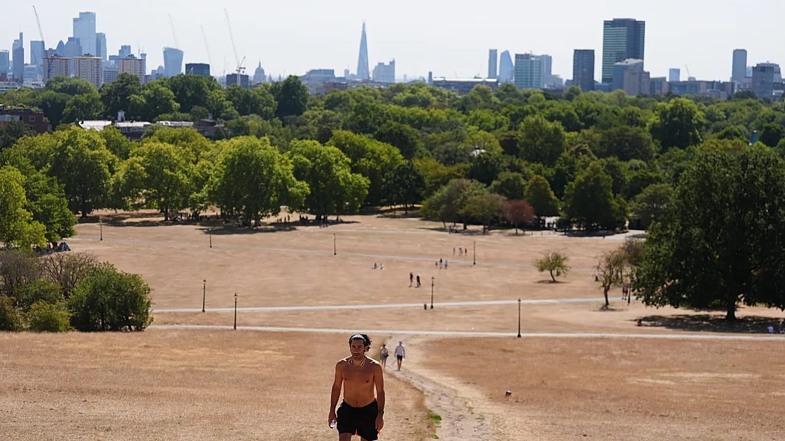 Pessoa caminha em Primrose Hill, no norte de Londres, num domingo, 9 de agosto de 2026, com temperaturas previstas até 33 ºC em partes do Reino Unido
