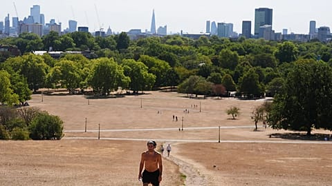 A person walking through Primrose Hill, as temperatures are expected to reach up to 33 °C in parts of the UK, in north London Sunday, Aug. 9, 2026.