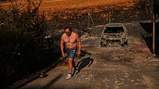 Julian Alonso caminha pela sua propriedade destruída por um incêndio florestal em El Encinar del Alberche, na província de Madrid, Espanha, quinta-feira, 30 de julho de 2026.