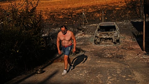 Julian Alonso walks on his property destroyed by a wildfire in El Encinar del Alberche, Madrid province, Spain, Thursday, July 30, 2026. 