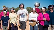 People wear protective glasses as they look up at a solar eclipse 