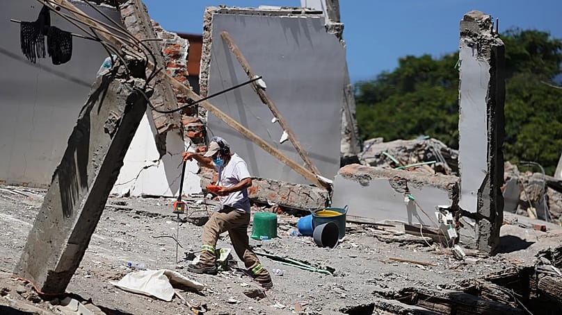 Ein Helfer setzt einen Scanner ein, um einen Tag nach dem Erdbeben in Cali, Kolumbien, am Dienstag, 11. August 2026, in den Trümmern nach Überlebenden zu suchen.