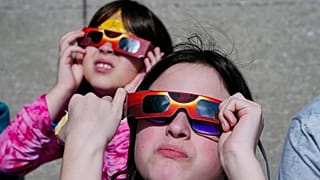 FILE- Evelyn Sander, right, and Sopfia Munoz, of Indianapolis, look at the eclipse during total eclipse viewing event in Indianapolis,Monday April 8, 2024. 