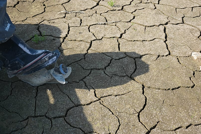 Boats lie on the dried riverbed at a tourist dock along the Po river during a drought in Torricella, Italy, Monday, Aug. 10, 2026.