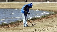 Ein Mensch sucht mit einem Metal-Detektor im Sand. (Symbolbild)