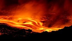 Na Etnie wciąż trwa aktywność erupcyjna. Strumienie lawy spływają po zboczach wulkanu, widziane z Serracozzo 11 sierpnia 2026 r. (AP Photo/Simone Genovese)