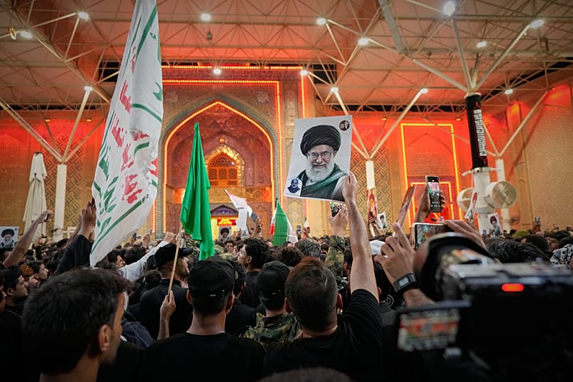 مشـيّعون يرفعون رايات دينية وصورة للمرشد الإيراني الراحل علي خامنئي أمام مرقد الإمام علي في النجف بالعراق، عشية مراسم التشييع، 7 تموز 2026.