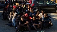 ARCHIVO: Migrantes que cruzaron de Marruecos a España hacen fila para recibir alimentos en una playa del enclave español de Ceuta, el lunes 3 de agosto de 2026.