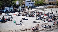 Migrants who crossed into Spain from Morocco gather on a beach in the Spanish enclave of Ceuta, 2 August, 2026