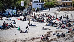 Migrants who crossed into Spain from Morocco gather on a beach in the Spanish enclave of Ceuta, 2 August, 2026