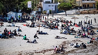 Migrants who crossed into Spain from Morocco gather on a beach in the Spanish enclave of Ceuta, 2 August, 2026