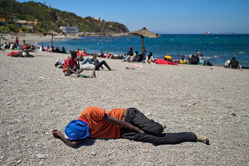 A migrant who crossed into Spain from Morocco sleeps on a beach in the Spanish enclave of Ceuta, 2 August, 2026