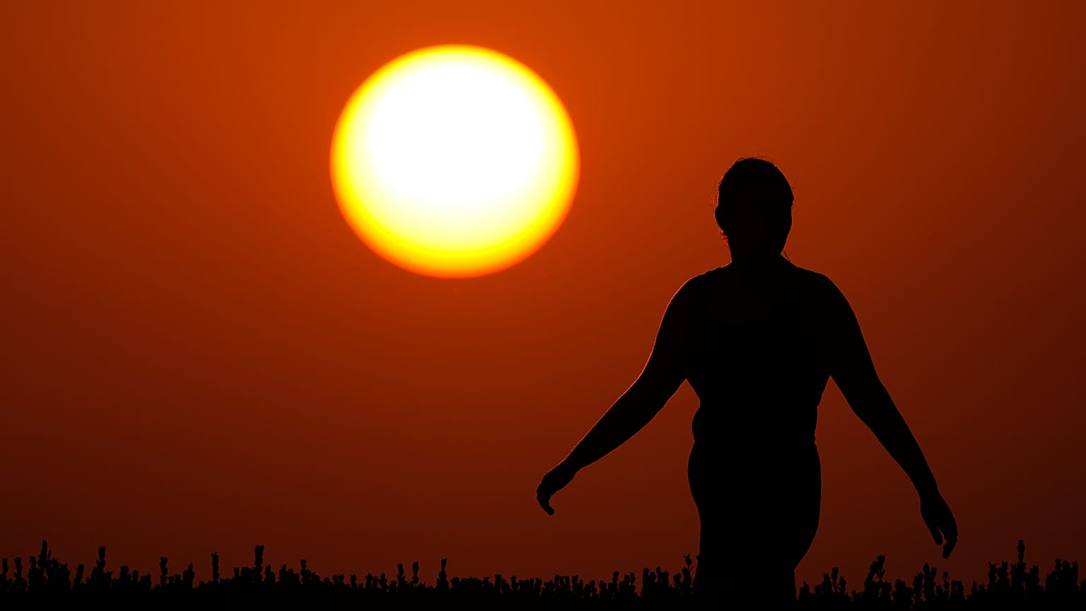 امرأة تشاهد غروب الشمس في نهاية يوم صيفي حار، الأحد 26 يوليو 2026، في مدينة كانساس سيتي بولاية ميسوري. (صورة من وكالة أسوشيتد برس/تشارلي ريدل)
