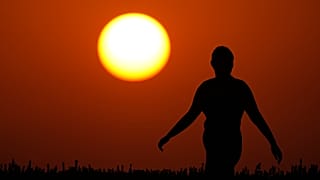 امرأة تشاهد غروب الشمس في نهاية يوم صيفي حار، الأحد 26 يوليو 2026، في مدينة كانساس سيتي بولاية ميسوري. (صورة من وكالة أسوشيتد برس/تشارلي ريدل)