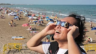A man wears special eclipse glasses before a total solar eclipse set to begin around sunset at a beach near Valencia, 12 August, 2026