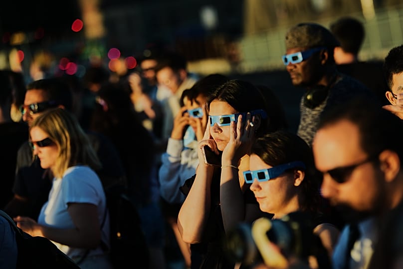 People use solar eclipse glasses to look up at the sun during a solar eclipse in Berlin, 12 August, 2026