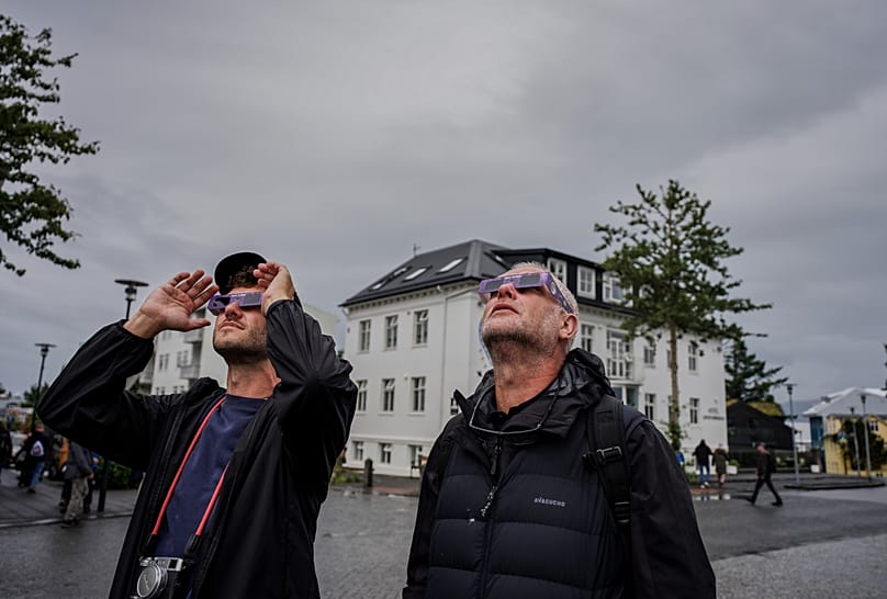 People use solar eclipse glasses to look up at the sun ahead of a solar eclipse Reykjavik, 12 August, 2026