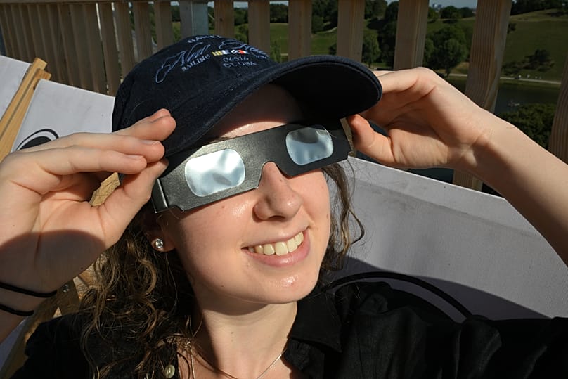 A woman wears safety goggles as she prepares to watch the partial solar eclipse in Munich, 12 August, 2026
