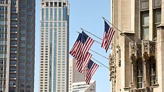أعلام أمريكية ترفرف على واجهة أحد المباني في الولايات المتحدة.