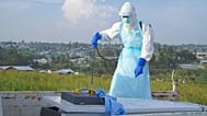 A health worker sprays the coffin containing the remains of Jacques Lobo Dhena, who died of Ebola, during a burial service in Bunia, Ituri province, eastern Congo, Wednesday, 