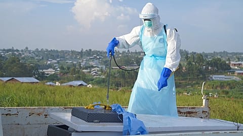 A health worker sprays the coffin containing the remains of Jacques Lobo Dhena, who died of Ebola, during a burial service in Bunia, Ituri province, eastern Congo, Wednesday, 
