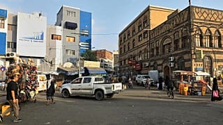 Varias personas pasan junto a vendedores de mercancías en una calle de Saná, Yemen, el sábado ocho de agosto de 2026. (Foto AP/Osamah Abdulrahman)
