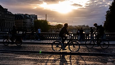 Des cyclistes circulent sur un pont enjambant la Seine au coucher du soleil, ce jeudi 28 août 2025, à Paris.