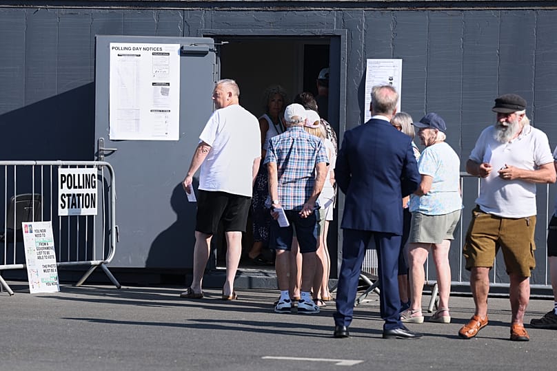 Voters queue at a polling station in Walton on the Naze, Thursday, Aug. 13, 2026 to cast their votes for the Clacton on Sea by-election.(AP Photo/Richard Pelham)