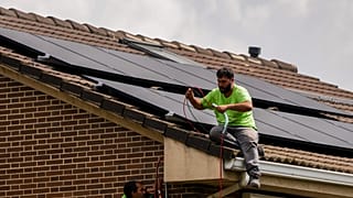 In this September 2022 file photo, a worker installs solar panels on the roof of a house in Rivas-Vaciamadrid, Spain.