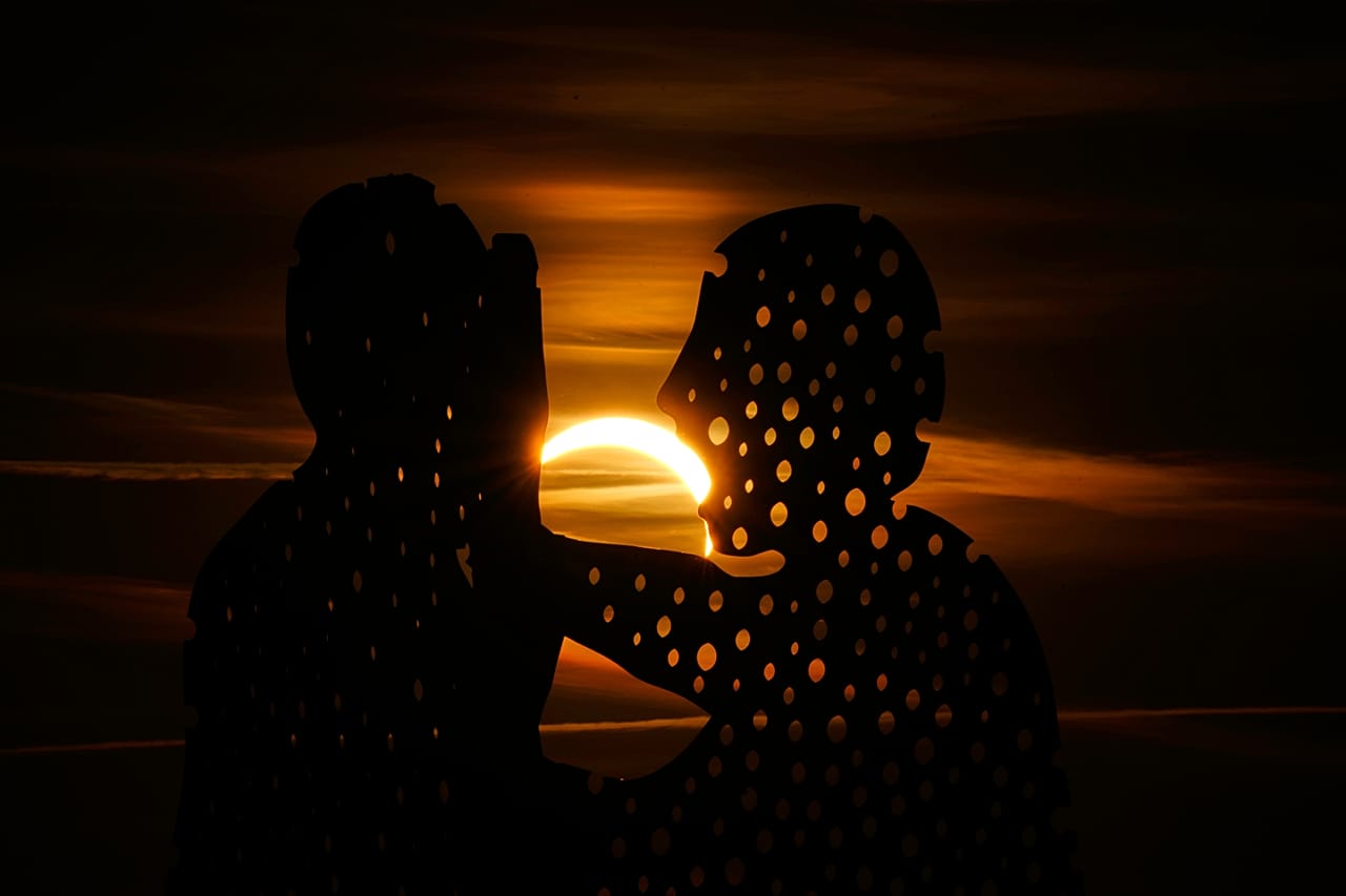 Der Mond verdeckt die Sonne teilweise bei der Sonnenfinsternis nahe der Molecule-Man-Skulptur in Berlin in Deutschland
