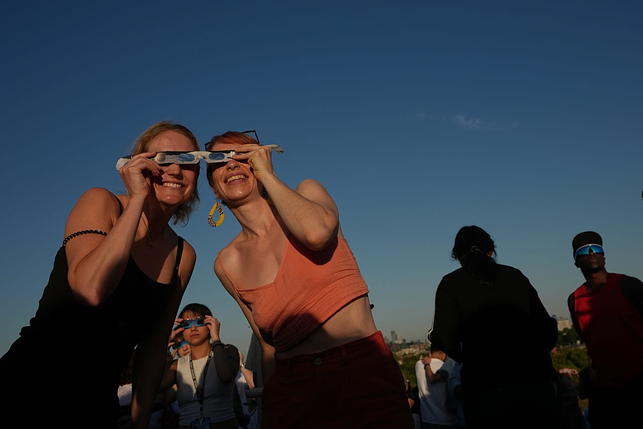 Menschen beobachten die Sonnenfinsternis auf dem Primrose Hill in London