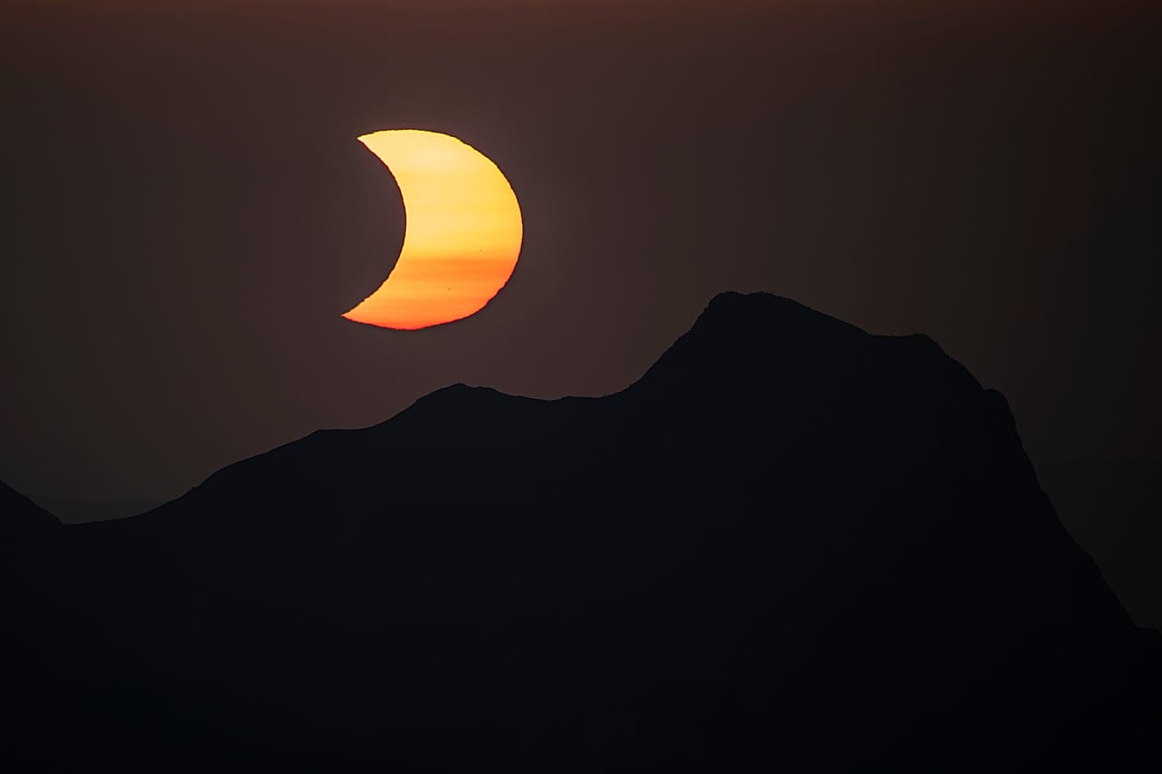 Der Mond verdeckt bei einer partiellen Sonnenfinsternis die Sonne über dem Gipfel des Gantrisch, gesehen vom Gipfel des Niesen im Berner Oberland in der Schweiz