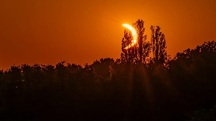 Solar eclipse seen from Pic du Midi in French Pyrenees as clouds partially obscure view