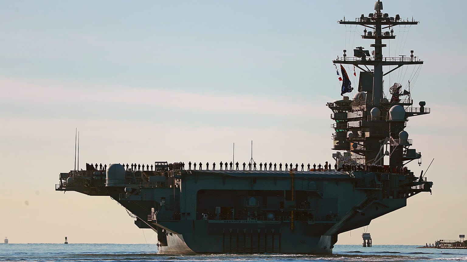 يصطف البحارة ومشاة البحرية على سطح حاملة الطائرات "يو إس إس أبراهام لينكولن" (CVN-72) أثناء مغادرتها سان دييغو يوم الاثنين، 3 يناير 2021