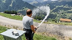 Juerg Klopfenstein, odpowiedzialny za naśnieżanie w Adelboden-Lenk, polewa wodą drogę przy stokach w Lenk w Szwajcarii, 3 sierpnia 2026 r.